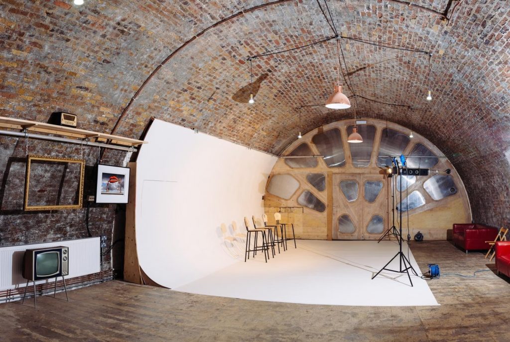 A well-lit, modern photo studio rental with professional lighting and backdrops, perfect for freelance photographers.